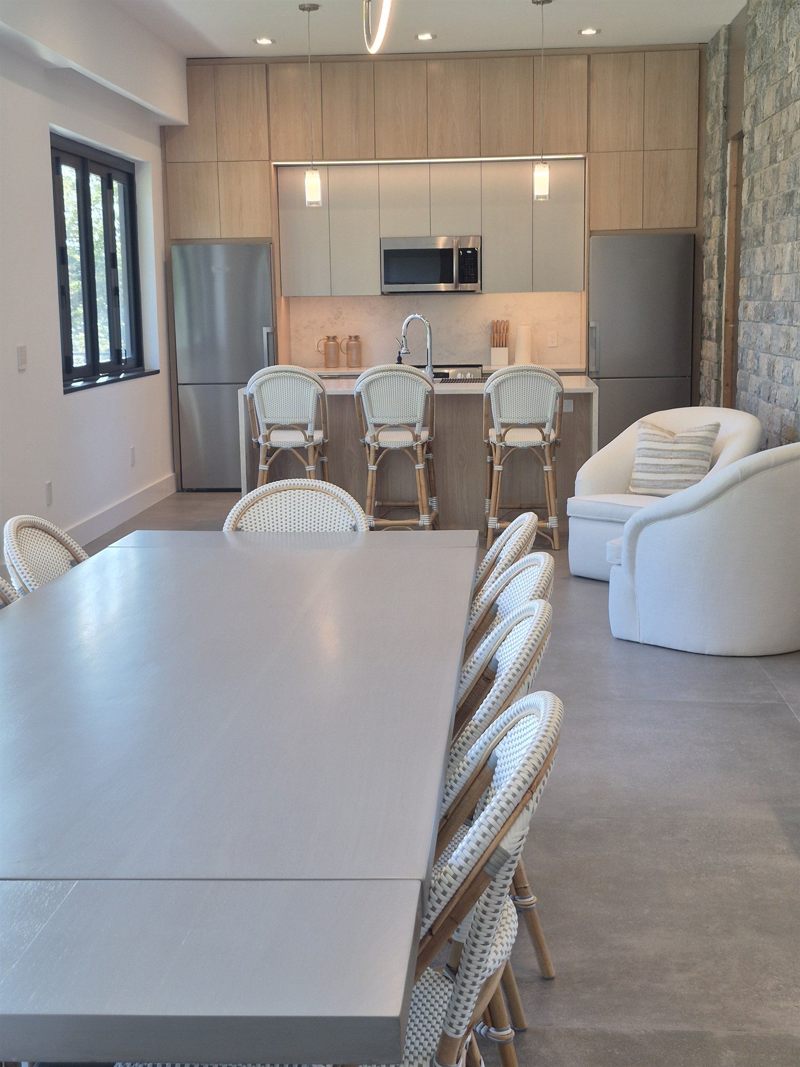 Full-height white-oak cabinetry fitted around a stone feature wall